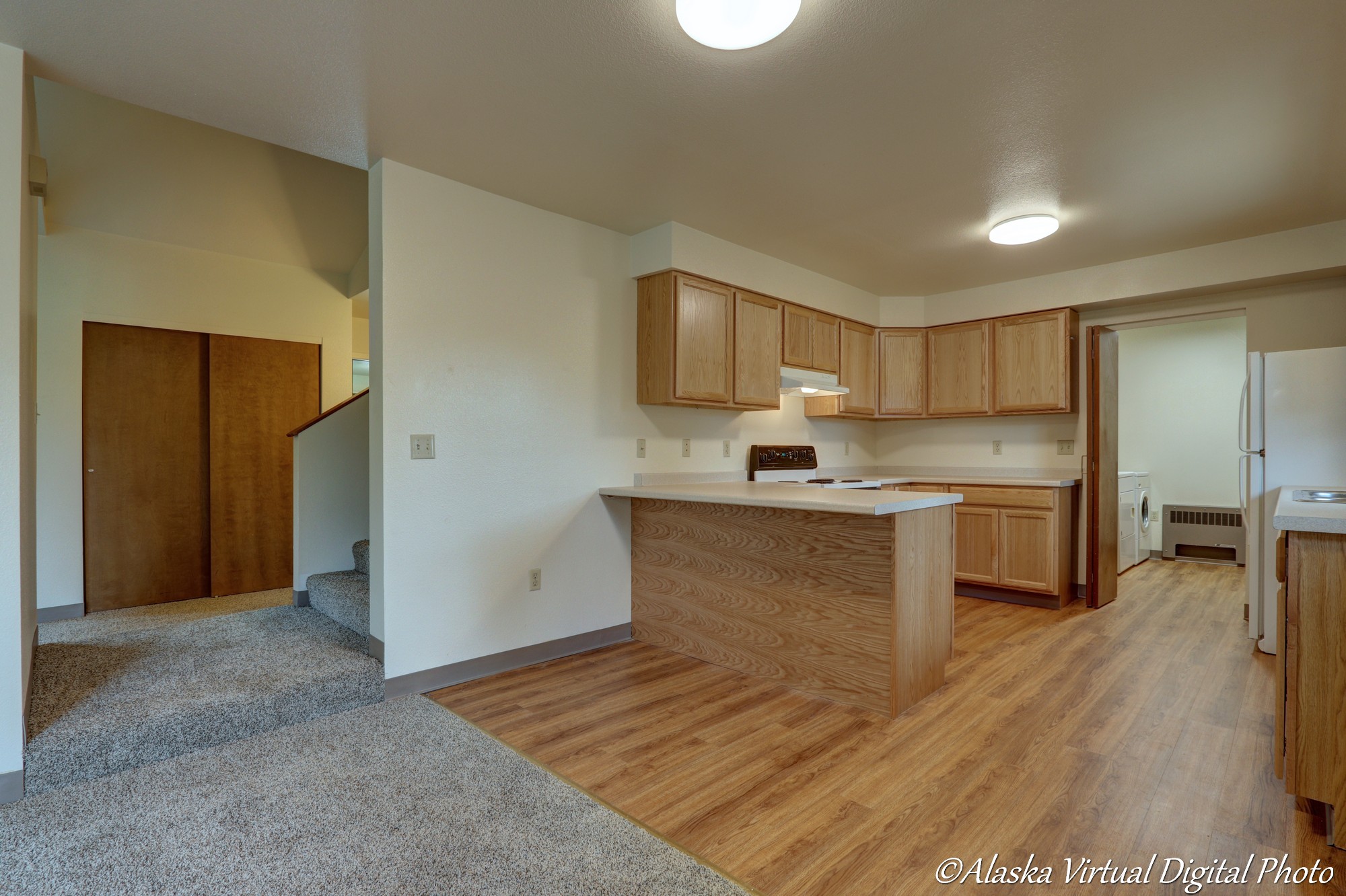 image from living room looking into open kitchen. View of bar countertop