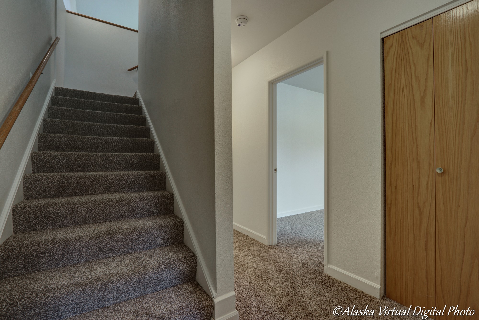 image of stairs that lead to living room. to the right is a bedroom and closet