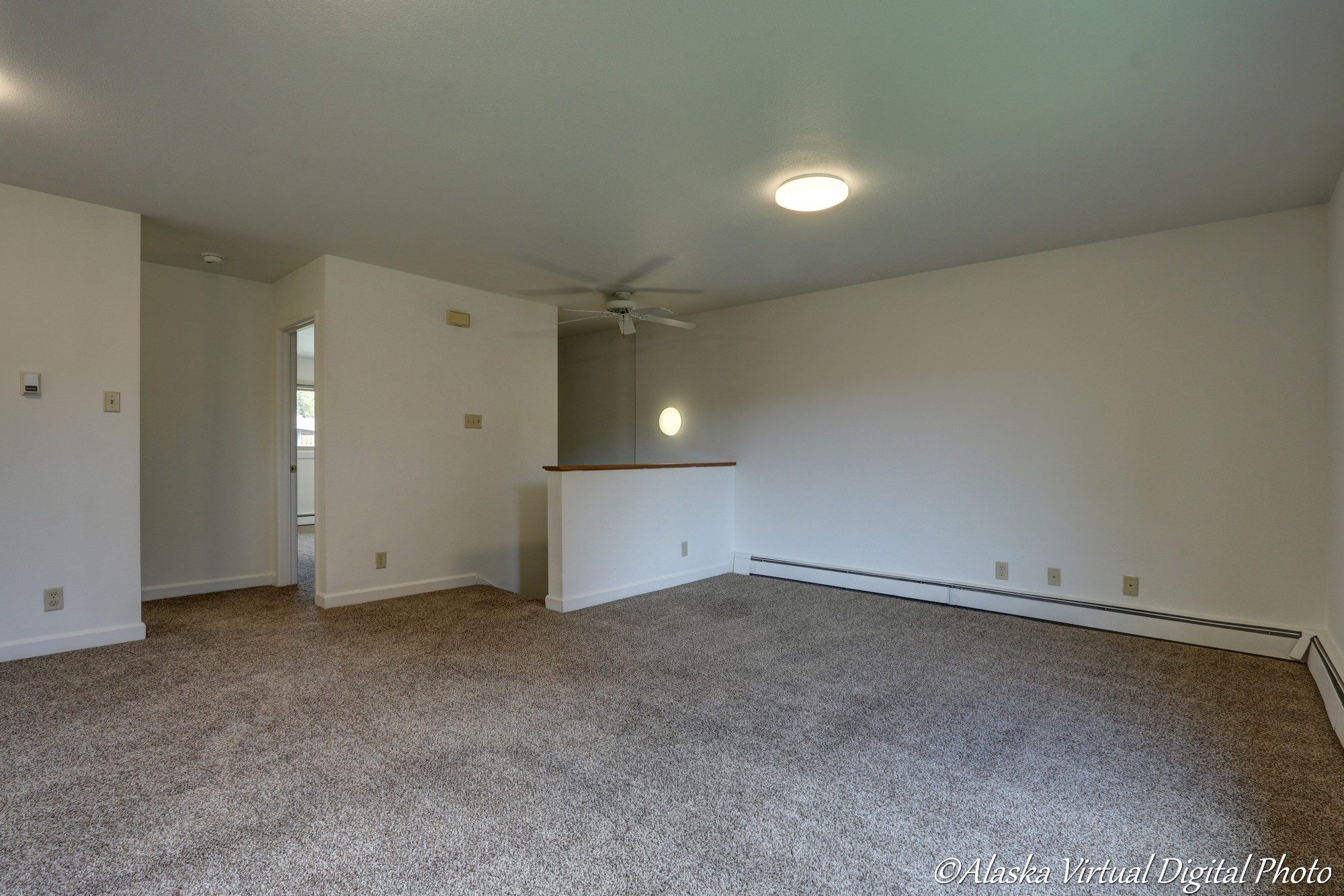 Image of carpeted living room with ceiling fan and circular LED light