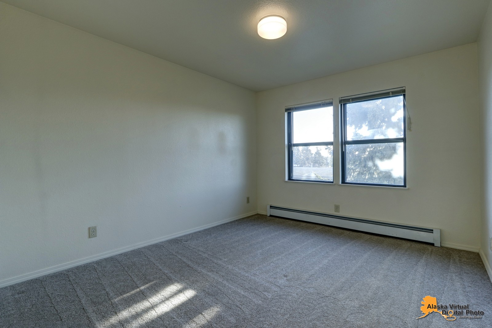 Bedroom in denali home with windows and baseboard heating