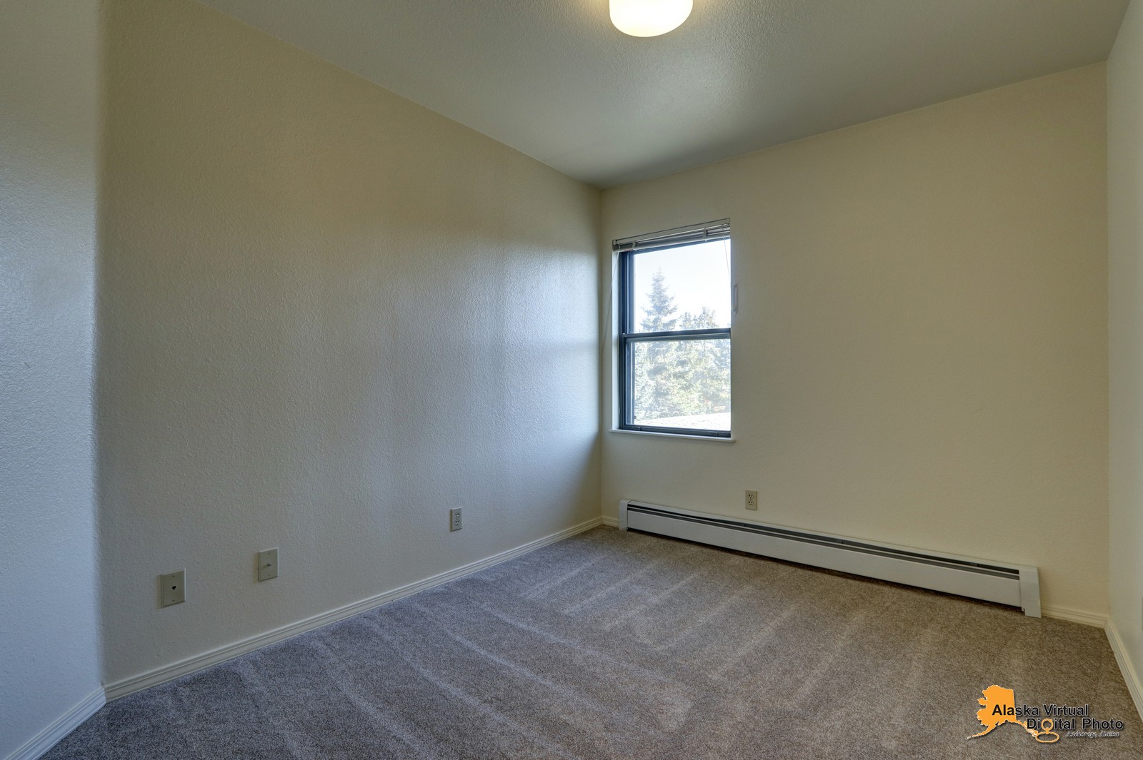 Bedroom in denali home with windows and baseboard heating