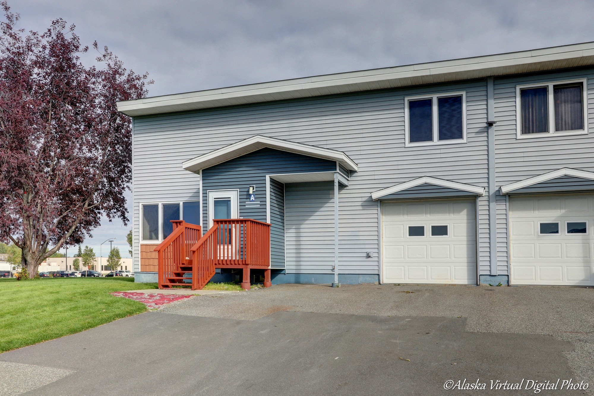 Light grey exterior of home with one car garage and red deck