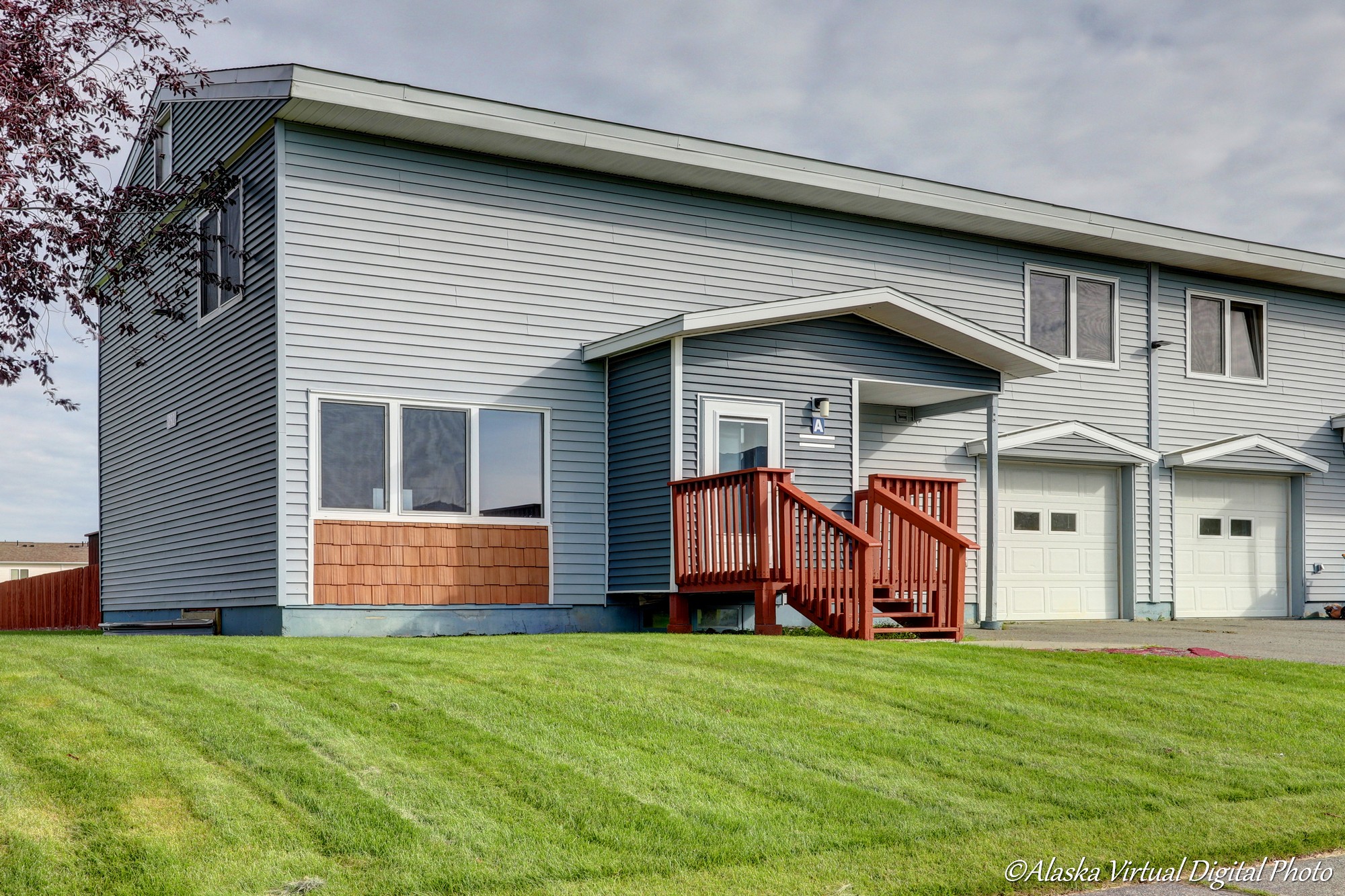 Light grey exterior of home with one car garage and red deck