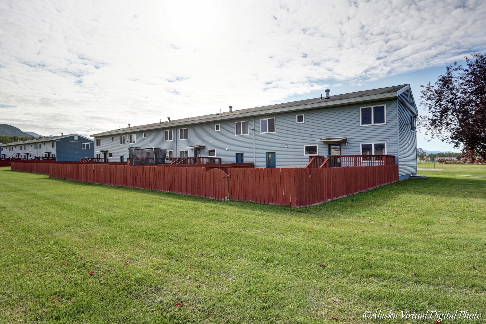 Rear of home with red fenced yard