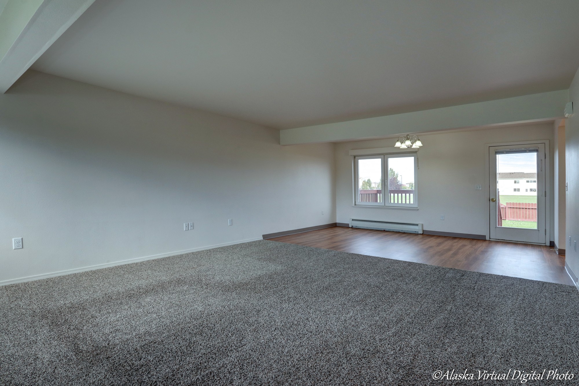 Carpeted living room with LVP dining room