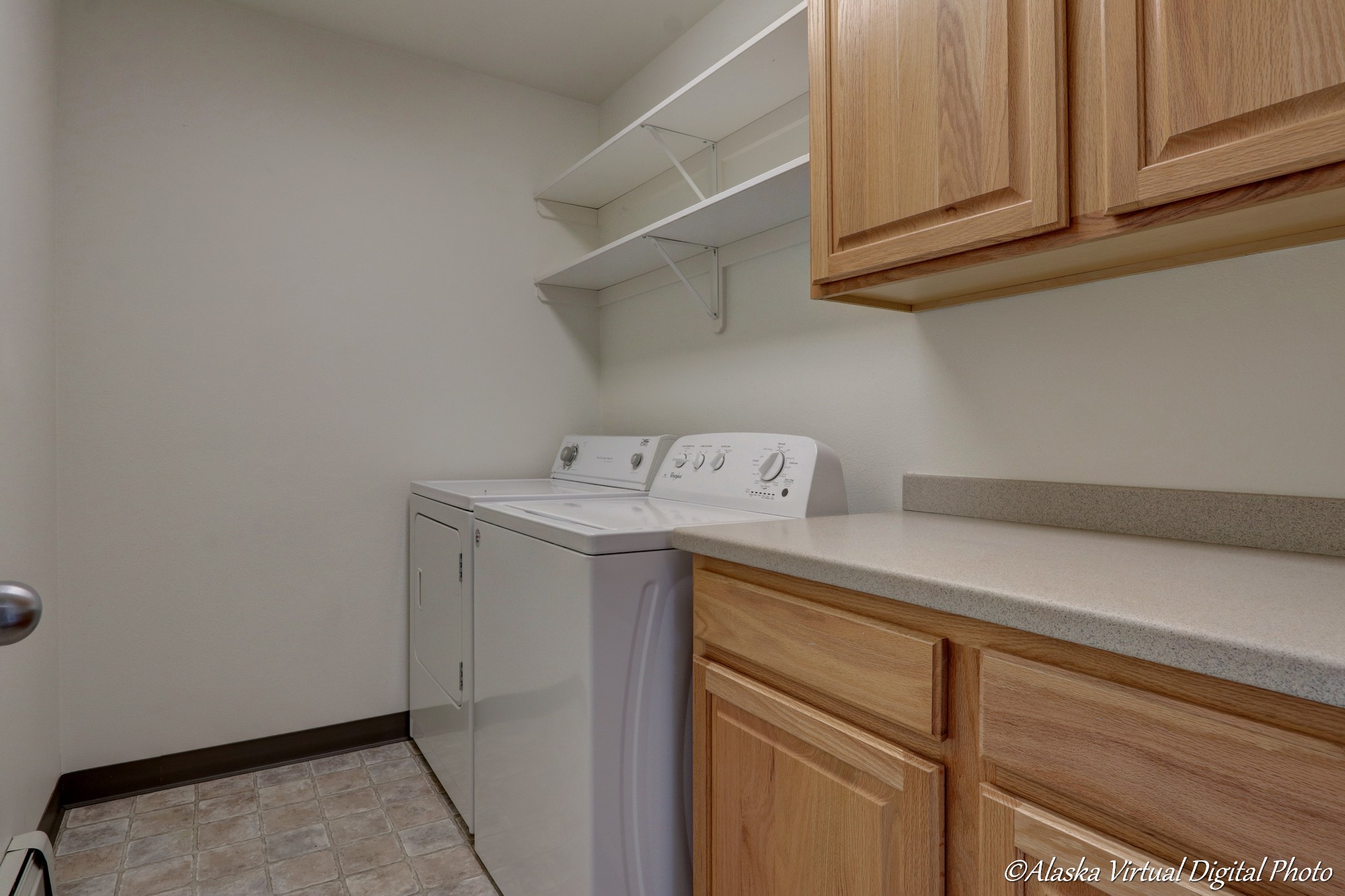 Image of washer and dryer as well as cabinets, counter tops in laundry room