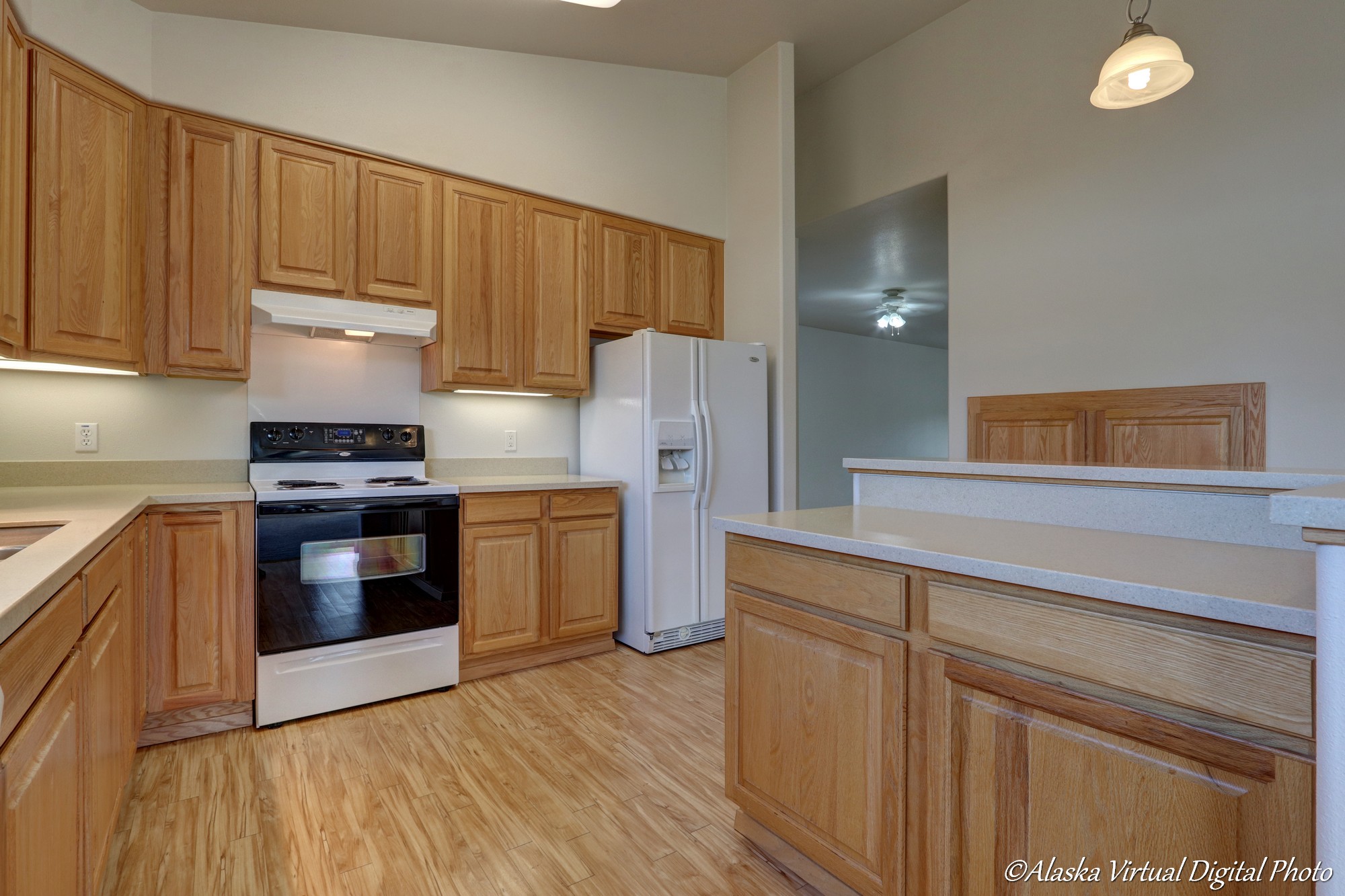 Kitchen with LVP flooring and light brown cabinets