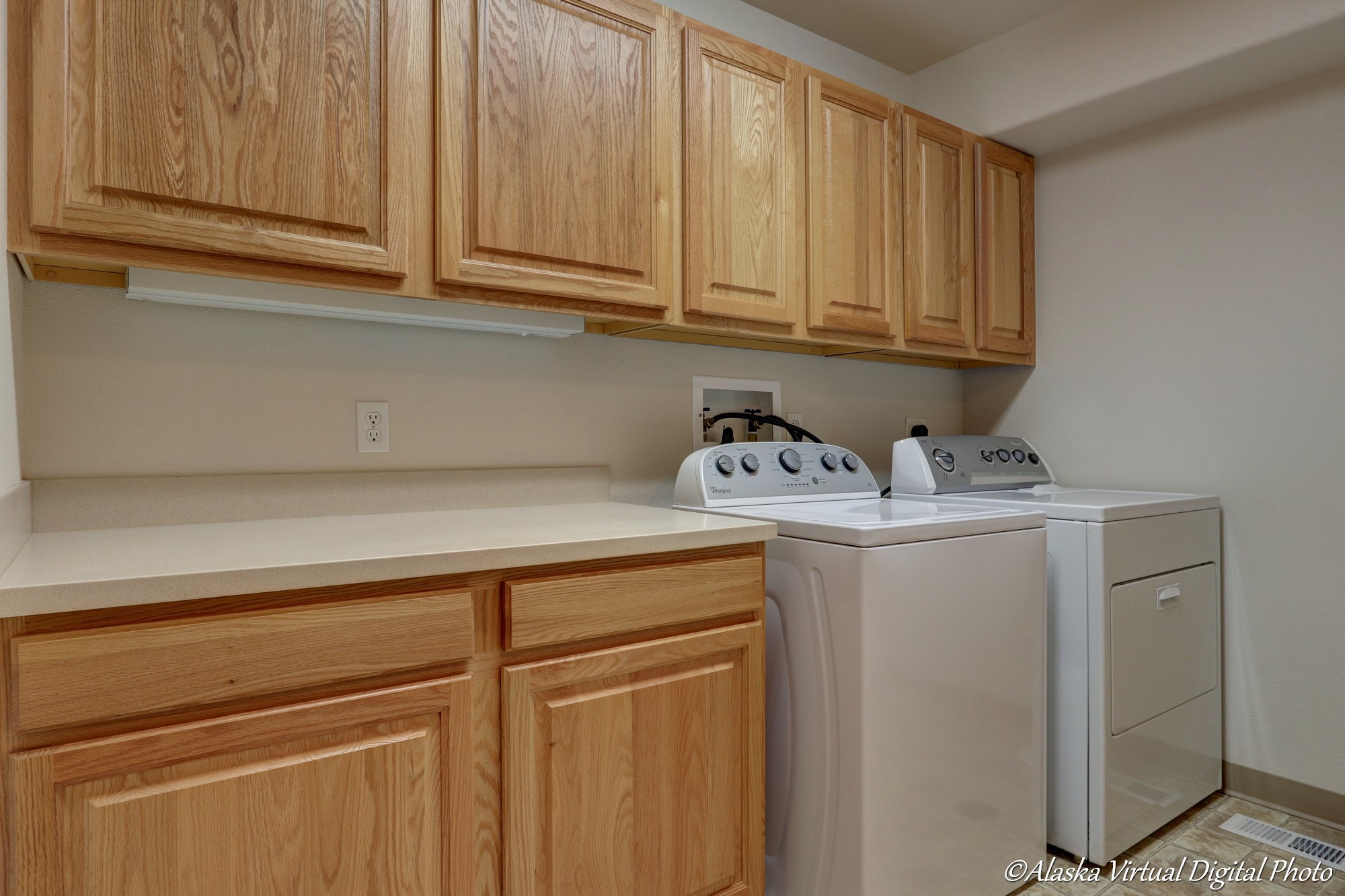 Laundry room with counters and multiple cabinets for storage