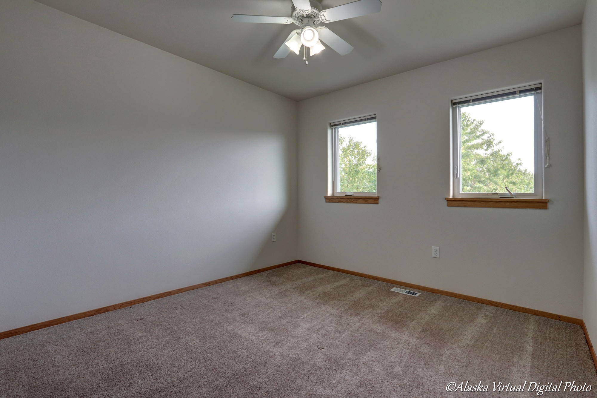 Bedroom with white fan and multiple windows