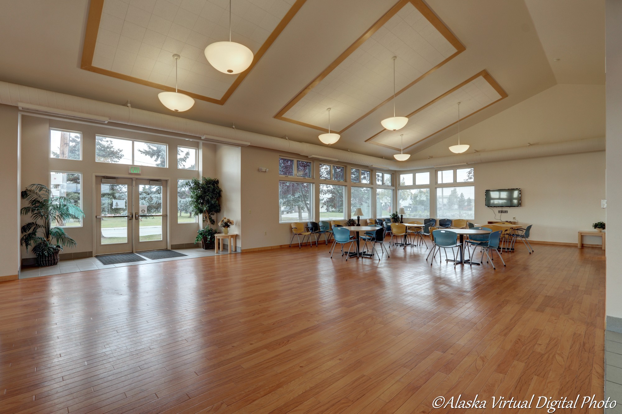 Photo of tables, chairs, and fireplace. Wood floors