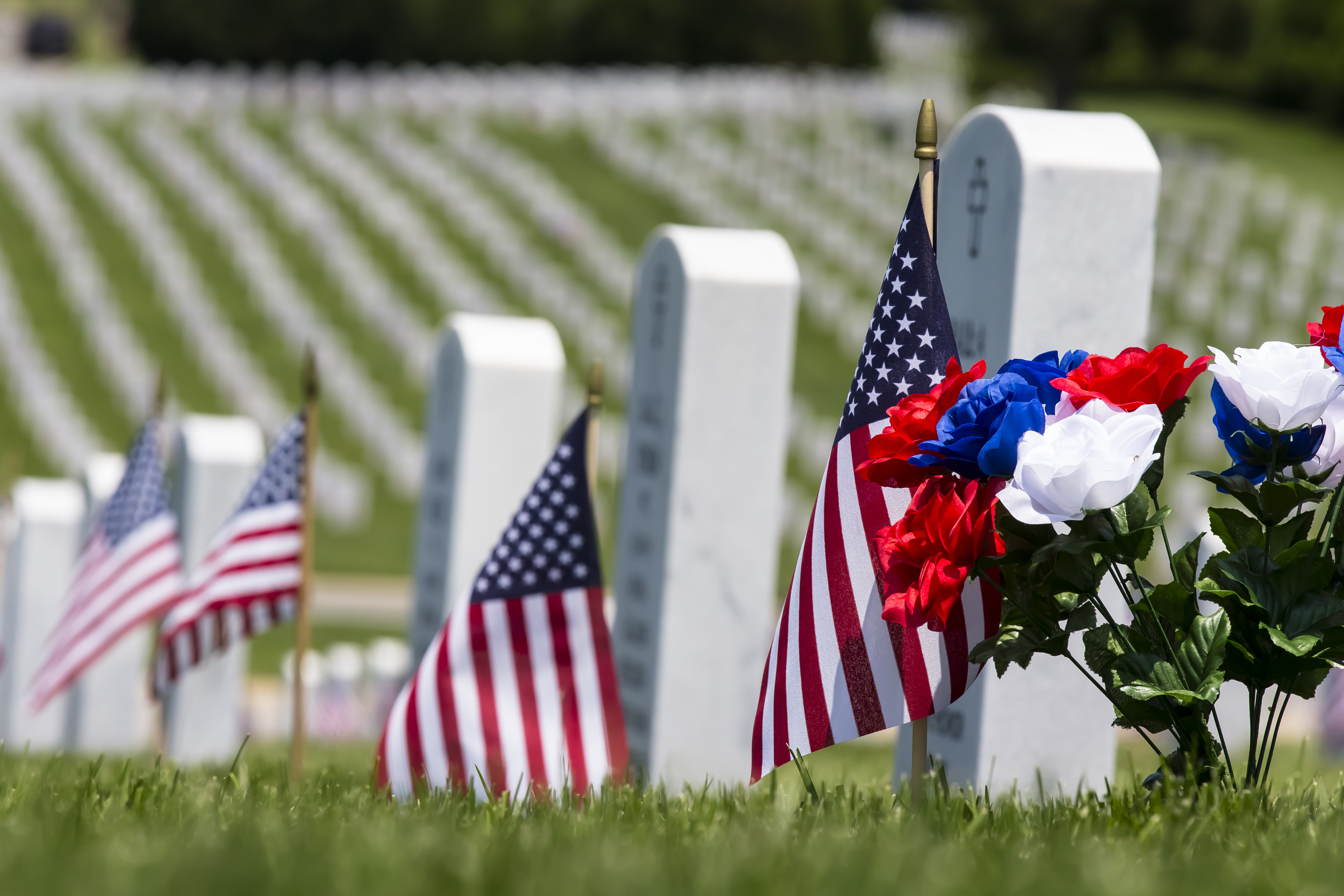 Close up of flags next to servicemembers' graves