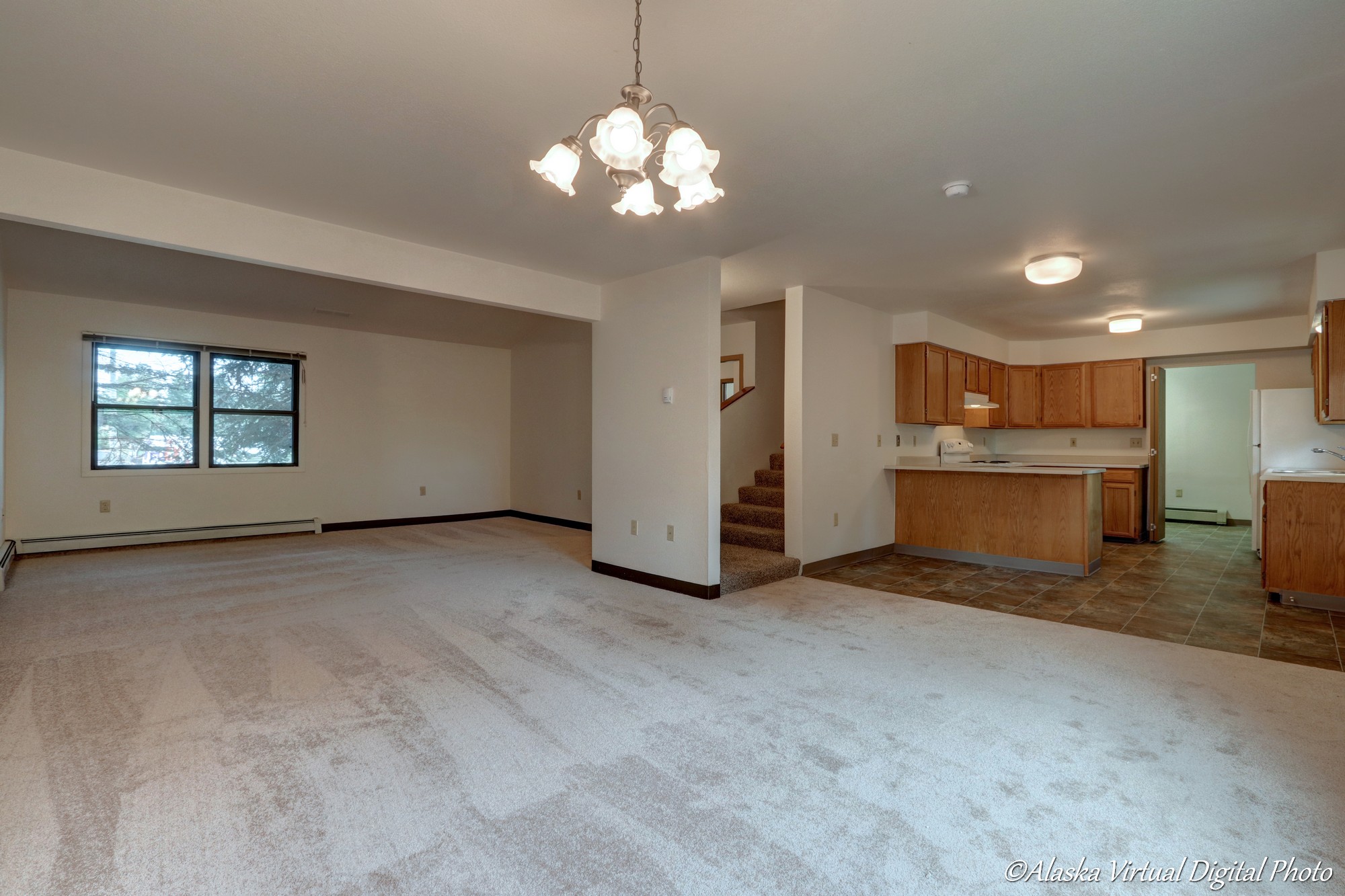 Photo from dining area with kitchen on right and living room on the left