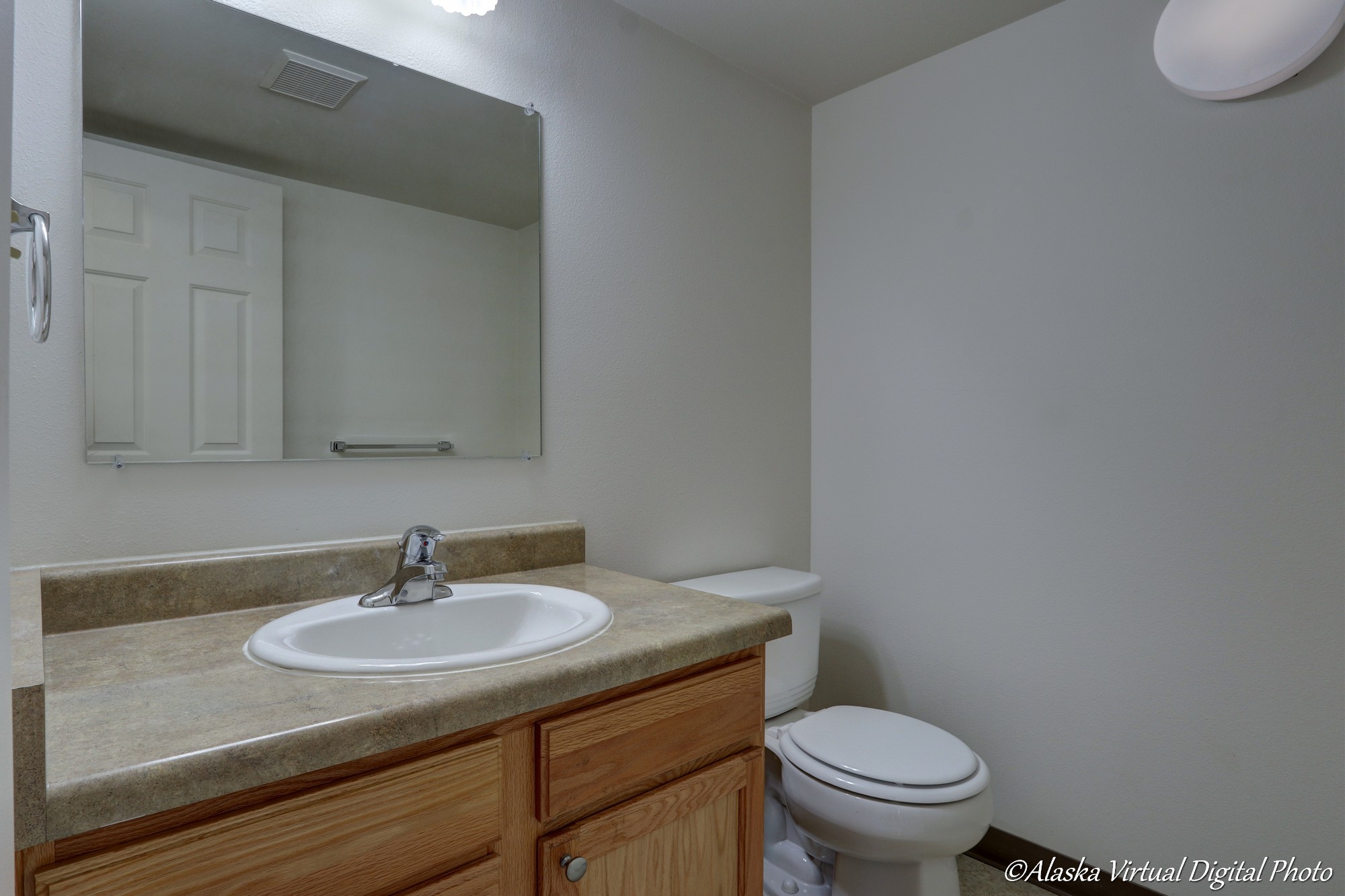 Image of sink, toilet, and mirror in downstairs powder room