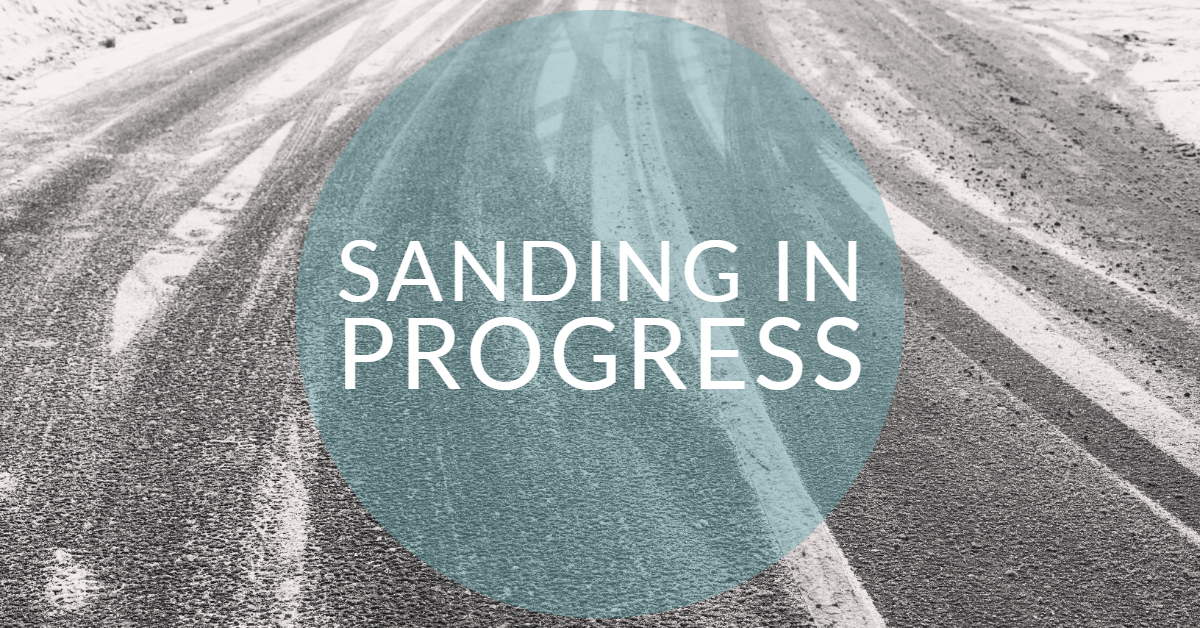 Road that has been sanded with streaks of snow