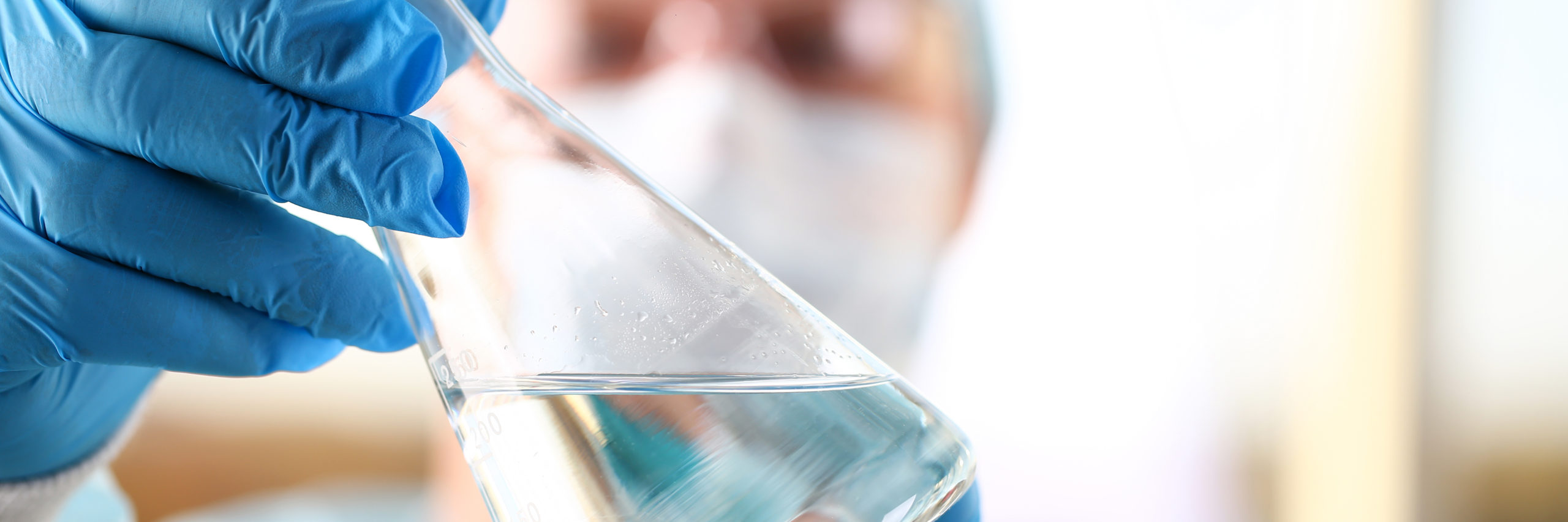 scientist holding vial of water in lab setting.