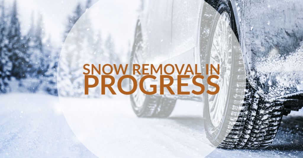 car on snowy road with snow removal in progress text transposed over