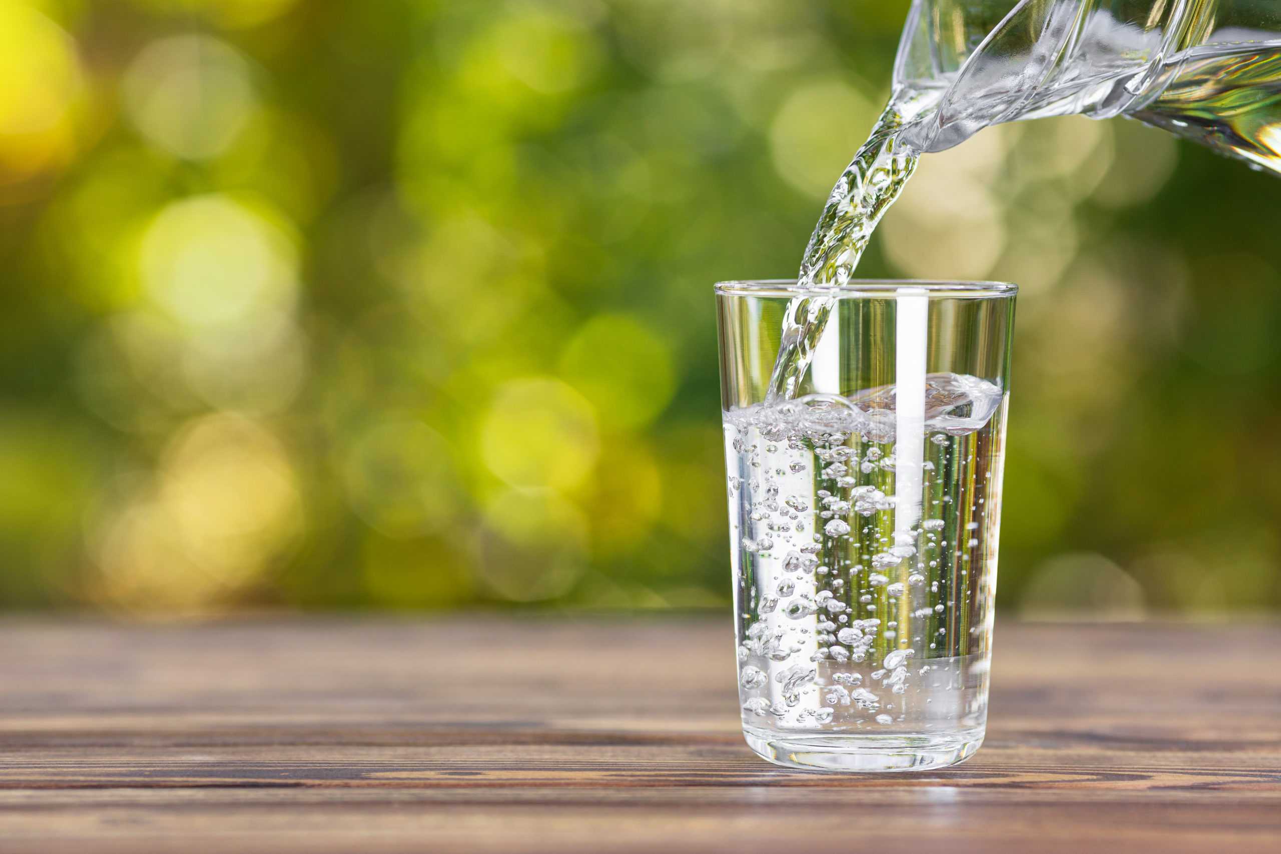 pouring water into a glass from a pitcher