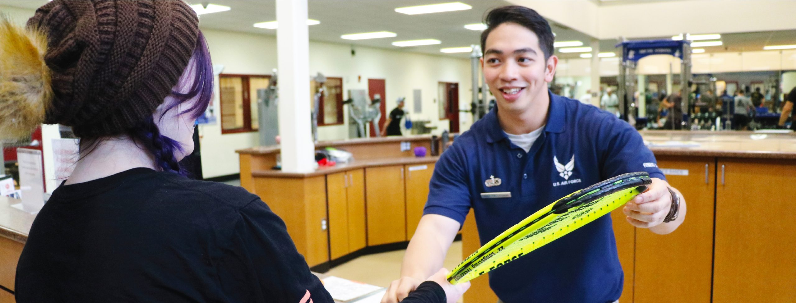 staff member assisting a customer with tennis racket rental