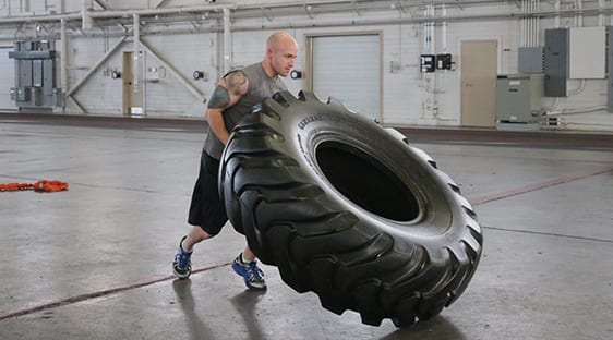 man lifting big tire