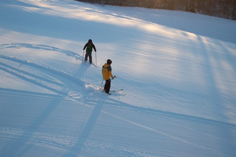 two individuals skiing down mountain